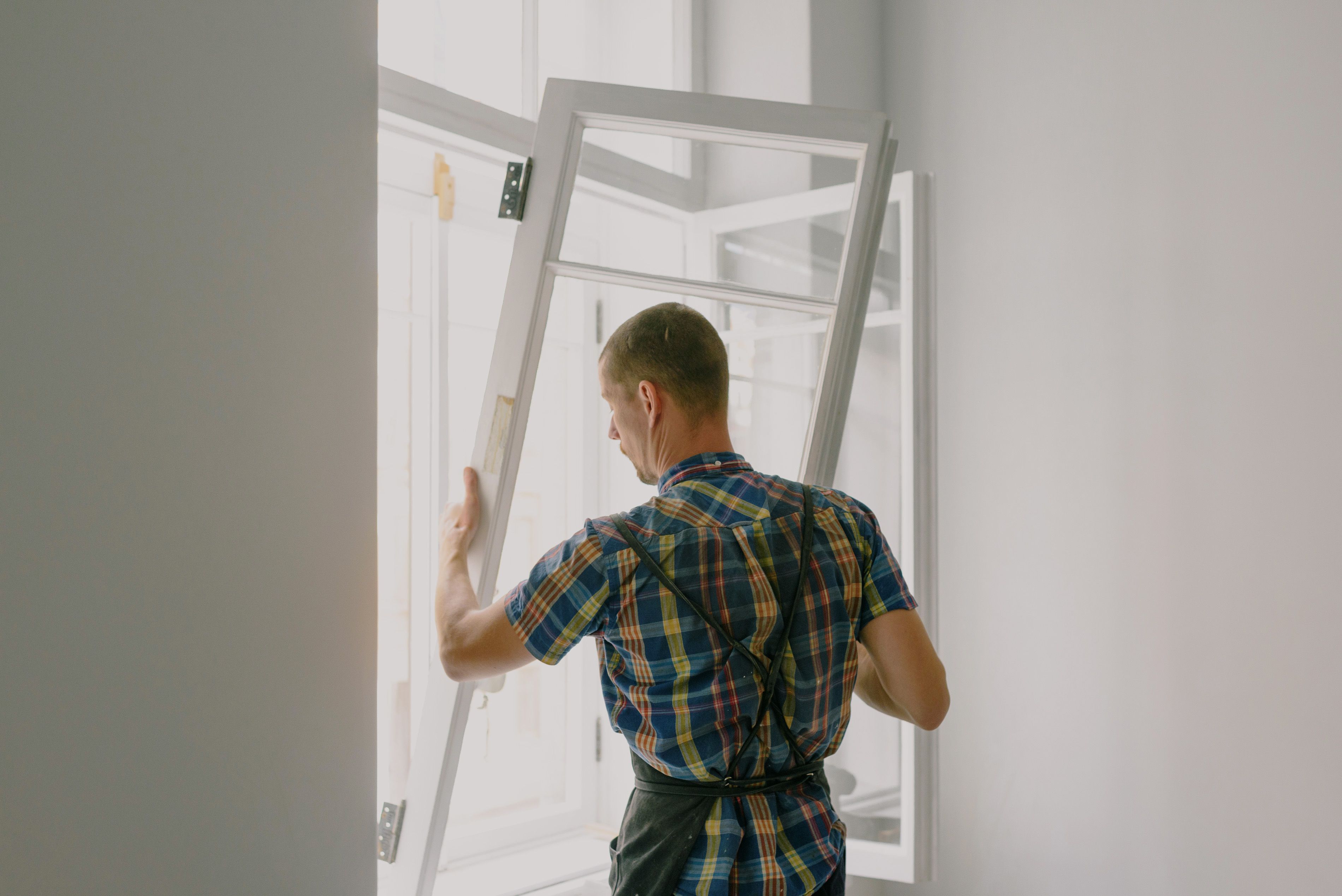Symbolbild: Ein Handwerker montiert ein Fenster; keine THS-Referenz.